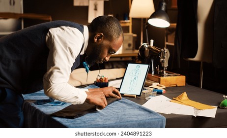 Craftsman measuring fabric in atelier, working on new custom made item with sewing tools and pins. Couturier designing fashion model with professional tailoring equipment. Handheld shot. - Powered by Shutterstock