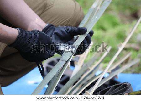 A craftsman measuring the width of a bamboo