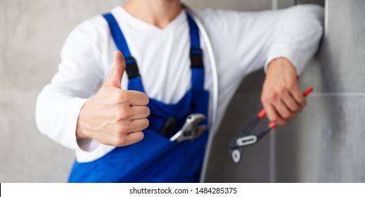 
craftsman points with his thumb upwards