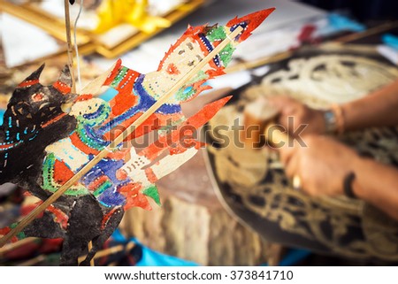 Craftsman processing thai famous shadow puppet from buffalo leather, handicraft art in the southern region of Thailand (selective focus)