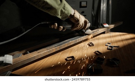 Craftsman in protective gloves and overall working with grinder at industrial plant, man silhouette grinding iron detail on the table in workshop. - Powered by Shutterstock