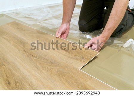   Craftsman renovating an apartment and laying a click vinyl floor covering                             