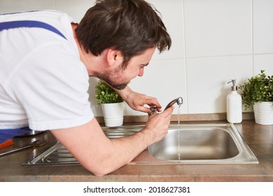 Craftsman Repairing A Leaky Faucet On The Kitchen Sink