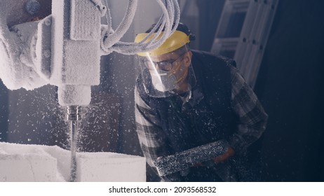 Craftsman In Respirator And Protective Face Shield Using Remote Control System And Watching Milling Machine Cutting Block Of Polystyrene In Workshop