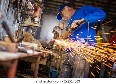 Craftsman sawing metal with disk grinder in workshop. - Powered by Shutterstock