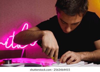 Craftsman with stationery knife making neon signboard in workshop	 - Powered by Shutterstock