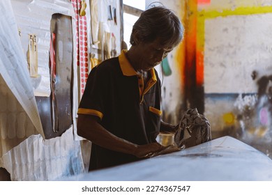 Craftsman surfboard working in a repair workshop - Powered by Shutterstock