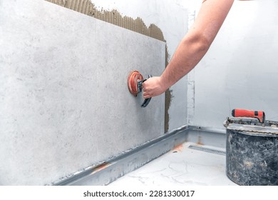 craftsman tiling the room with large format tiling - Shutterstock ID 2281330017