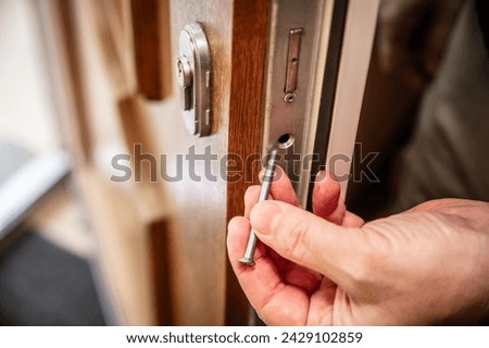 craftsman uninstalls a door lock cylinder, first removes the screw