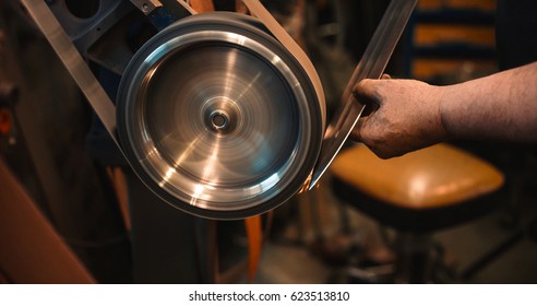 Craftsman uses a belt sander in a mechanical workshop. - Powered by Shutterstock