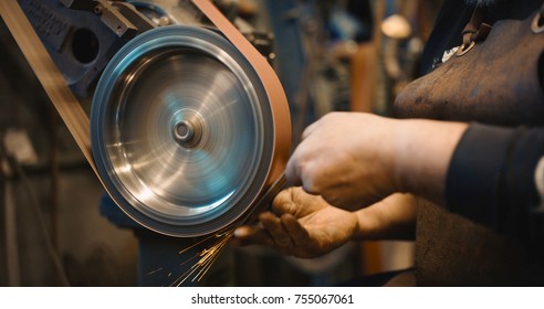 Craftsman uses a belt sander in a mechanical workshop. - Powered by Shutterstock