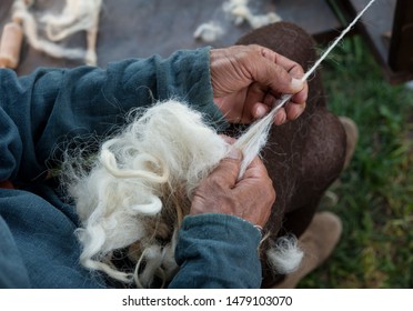 Craftsman using an old spinning wheel to turn wool into yarn. - Powered by Shutterstock