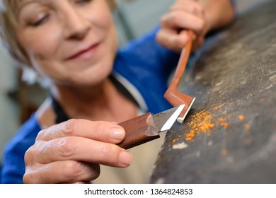 craftsman violin maker carving a bow in her workshop - Powered by Shutterstock