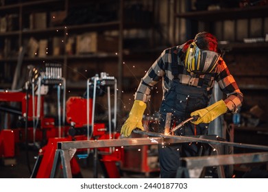 Craftsman welding the metal construction with great care and patience. Looking down while working and concentrating. Wearing safety equipment and long sleeves while working in a facility. Copy space. - Powered by Shutterstock