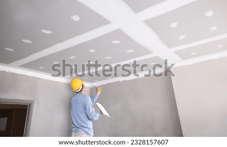 Craftsman working
with plaster gypsum ceiling for interior build gypsum board ceiling in construction sit.