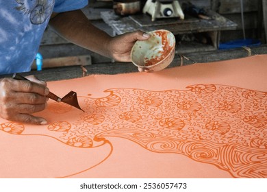 Craftsmanship of thai professional artist working use Tjanting tool or canting equipment and beeswax drawing batik ikat in handmade studio handicrafts workshop at Pak Bara of La ngu in Satun, Thailand - Powered by Shutterstock