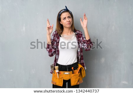 Craftsmen or electrician woman with fingers crossing and wishing the best