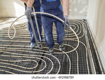 Craftsmen When Laying Pipes Of Underfloor Heating