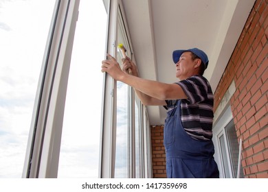 craftsmen workers install a window in the house rattle with a special rubber hammer - Shutterstock ID 1417359698