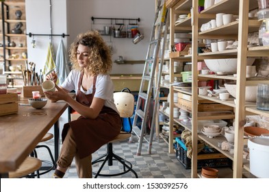 Craftsperson painting a bowl made of clay in art studio - Powered by Shutterstock