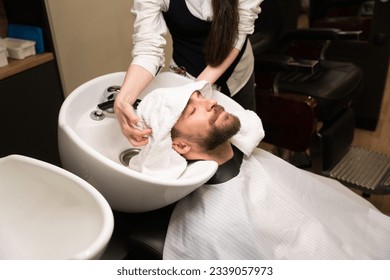 Craftswoman dries head of the client with a soft towel - Powered by Shutterstock