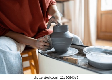 Craftswoman enjoying meditative process of making ceramics, female ceramist shaping clay on pottery wheel while working in studio, selective focus. Craft business and creative hobby concept - Powered by Shutterstock