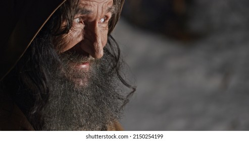 Crafty Elderly Man Checking Golden Coin