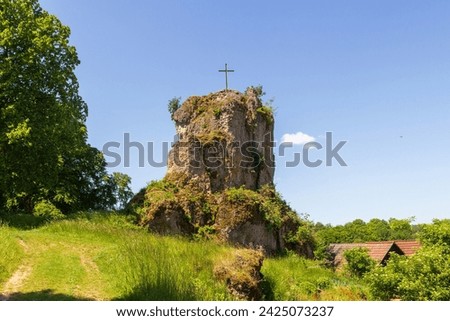 Craggy hill spur Bergschmidtsknock with summit cross at ruin of Bärnfels Castle near Obertrubach in Franconian Switzerland, Germany