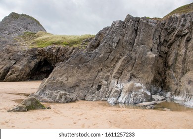 A craggy little cave opening in the cliff face at Three Cliffs Bay, The Gower Peninsula, Wales