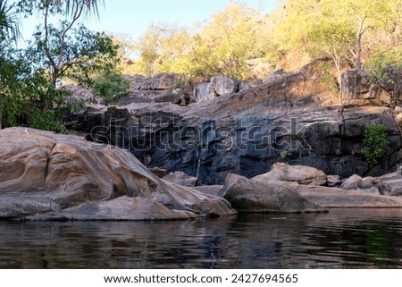 Craggy, rocky terrain with natural billabong water in outdoor wilderness of Kakadu in Northern Territory of Australia