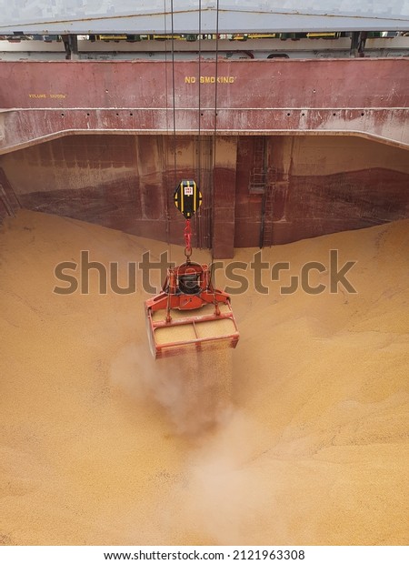 A crago grab is grabbing\
grain cargo from a hold of bulk carrier during discharging\
operation.