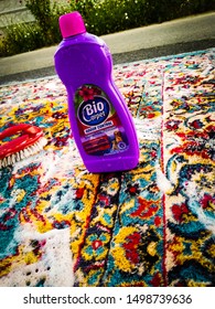 Craiova/Romania - 08.05.2019 : Bio Carpet Odour Control For Washing. Washing A Colored Carpet With Organic Detergent And A Red Brush. 