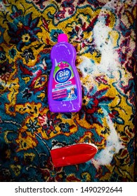 Craiova/Romania-08. 28.2019: Bio Carpet Odour Control For Washing. Washing A Colored Carpet With Bio Detergent And A Red Brush. 