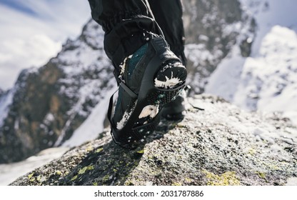 Crampons And Shoes Walking On Ice And Snow During Outdoor Winter Trekking. Close Up.