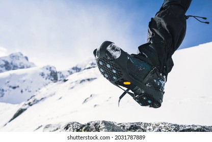 Crampons And Shoes Walking On Ice And Snow During Outdoor Winter Trekking. Close Up.