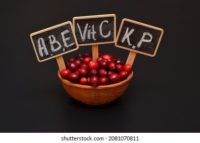 cranberries and tablets with the names of the vitamins contained in the berries