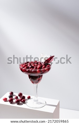 Cranberry cocktail on a white stand and gray and red background
