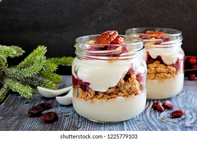 Cranberry granola parfaits in mason jars with a dark background - Powered by Shutterstock