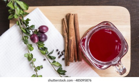 Cranberry Juice With Cinnamon And Herbs In Glass On Chopping Board Flat Lay Top View