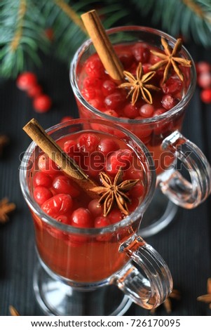 
Cranberry Morse in glasses against the background of fir branches on a dark wooden table