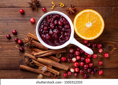 Cranberry sauce in ceramic saucepan with ingredients for cooking on kitchen wooden table from above. - Powered by Shutterstock