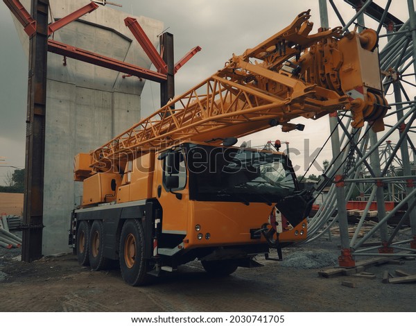 Crane car on construction
site, construction industry, yellow color, bridge construction,
workplace