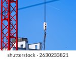 Crane with chain and hook at construction site of Swiss City of Opfikon on a sunny spring day. Photo takaen April 30th, 2025, Glattbrugg Opfikon, Switzerland.
