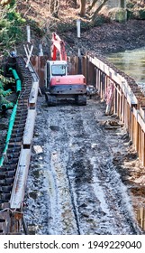 Crane Excavator For Driving Steel Sheet Piles To Stabilize The Banks Of The River Oker In Brunswick, Germany, March 8, 2021