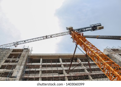 
Crane Forced By Construction Workers Lifting The Steel Bar To Dismantle The Scaffolding From The Building The Top Is Dull And Cloudy Sky.