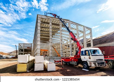 The crane ( HIAB ) extend its lift bucket to roof of the new building for isolation in the construction site. HIAB is a Swedish manufacturer of loader cranes, demountable container handlers, forestry.