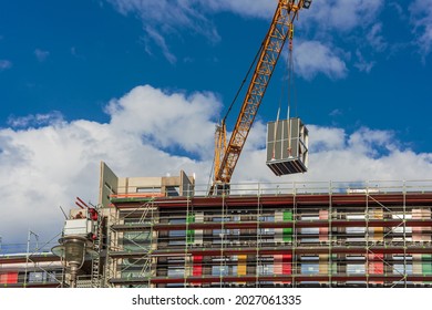 A Crane Is Lifting A Building Module To Its Position In The Structure. Construction Site Of A New Modular Timber Construction Office Building. 