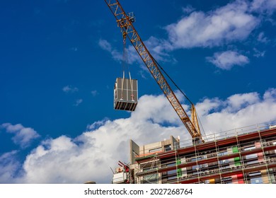 A Crane Is Lifting A Building Module To Its Position In The Structure. Construction Site Of A New Modular Timber Construction Office Building. 