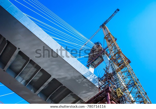 The crane lifts the\
load to a height. Construction of the bridge. The crane works on\
the construction site.