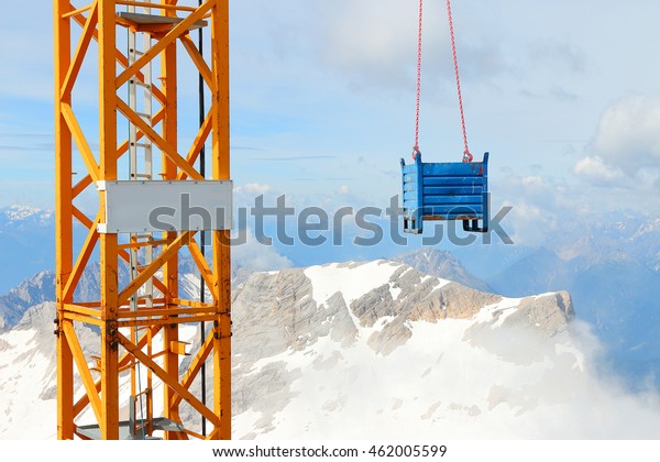 Crane with load on Germany\'s highest construction\
site in 2962m. Building the new Zugspitze cable car for tourists\
and skiers.